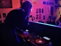 Une dj femme aux platines, ambiançant une foule dans un club.
