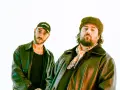 Deux DJ les plus connus, l'un porte une casquette et l'autre un bonnet en fourrure, posent devant un fond blanc.