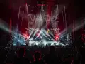 Scène de concert de Tagada Jones, éclairée par des projecteurs rouges et blancs. La foule en délire est au premier plan.