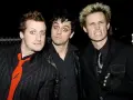 Les membres de Green Day, Billie Joe Armstrong, Mike Dirnt et Tré Cool, posent ensemble. Armstrong a les yeux écarquillés, Dirnt a un regard intense et Cool fait une grimace.
