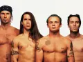 Les membres des Red Hot Chili Peppers, torse nu, posent pour une photo. L'âge ne semble pas avoir d'emprise sur leur énergie.
