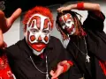 Deux membres du groupe Insane Clown Posse, visage peint en clown, cheveux rouges et dreadlocks, portent des chemises noires et des bandanas rouges.