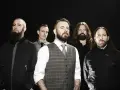 Cinq hommes barbus, membres du groupe In Flames, posent devant un fond noir.