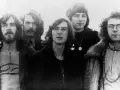 Cinq membres de King Crimson posent ensemble, arborant des coiffures et des vêtements typiques des années 70.