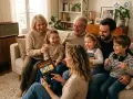 Une famille rit en choisissant un style de musique sur une tablette, créant une ambiance joyeuse.