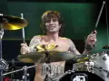 Tommy Lee, batteur du groupe, frappe sur sa batterie, torse nu, tatoué, en plein concert.
