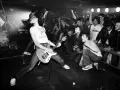 Un groupe rock irlandais des années 90 en pleine action. Le guitariste, cheveux au vent, électrise la foule en délire.