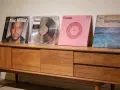 Collection de vinyles de Mac Miller : "Mac Miller", "Faces", "Circles" et "Swimming" sur un meuble en bois.