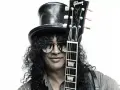 Le guitariste Slash, avec son chapeau haut-de-forme et ses lunettes de soleil, pose avec sa guitare Gibson Les Paul.