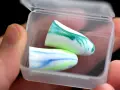 Deux boules quies colorées dans leur boîte, pour un sommeil paisible et sans acouphène.