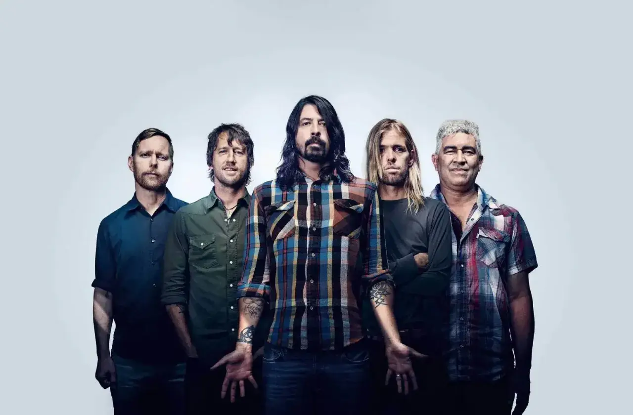 Les cinq membres du groupe Foo Fighters posent ensemble, prêts à faire vibrer le public avec leur musique.
