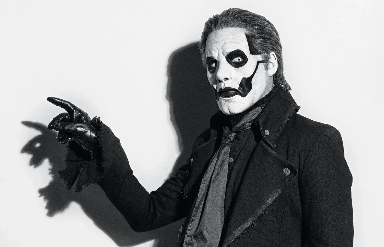 Le chanteur de Ghost, Papa Emeritus IV, pointe du doigt avec un gant noir, son visage maquillé en squelette.