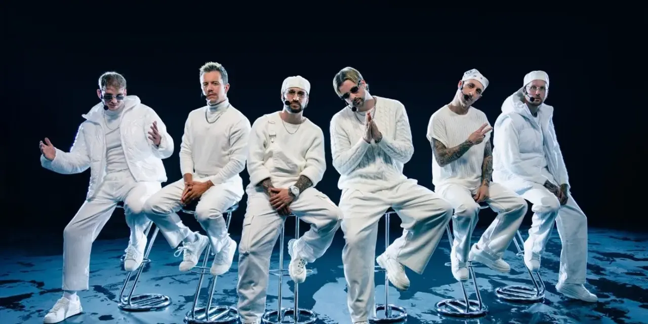 Six hommes en tenue blanche, assis sur des tabourets, évoquant l'univers des albums de Electric Callboy.