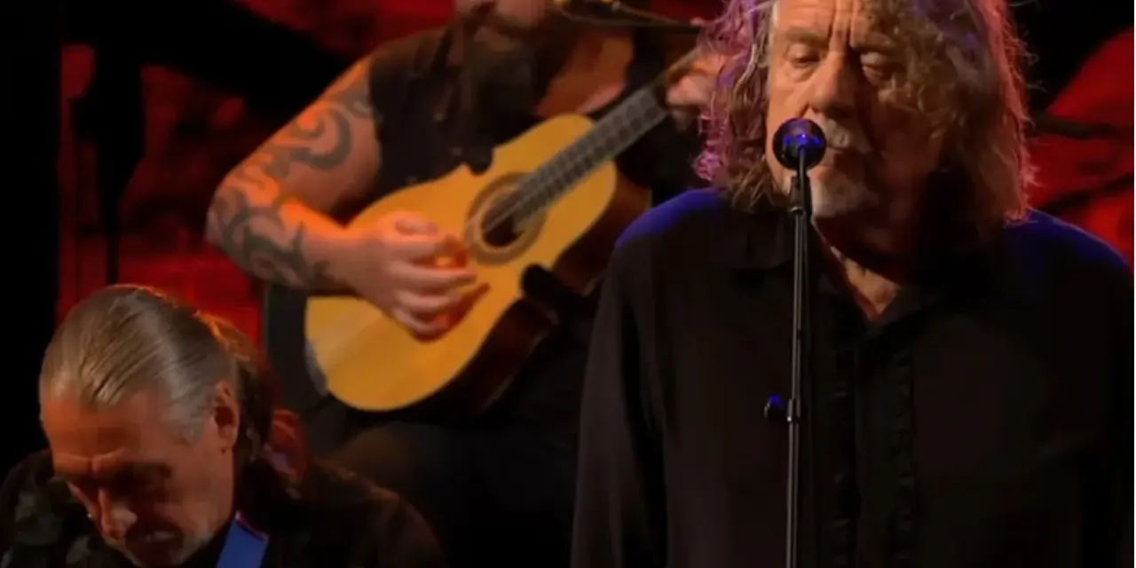 Robert Plant, le légendaire chanteur de Led Zeppelin, en pleine performance, accompagné de musiciens jouant de la guitare.