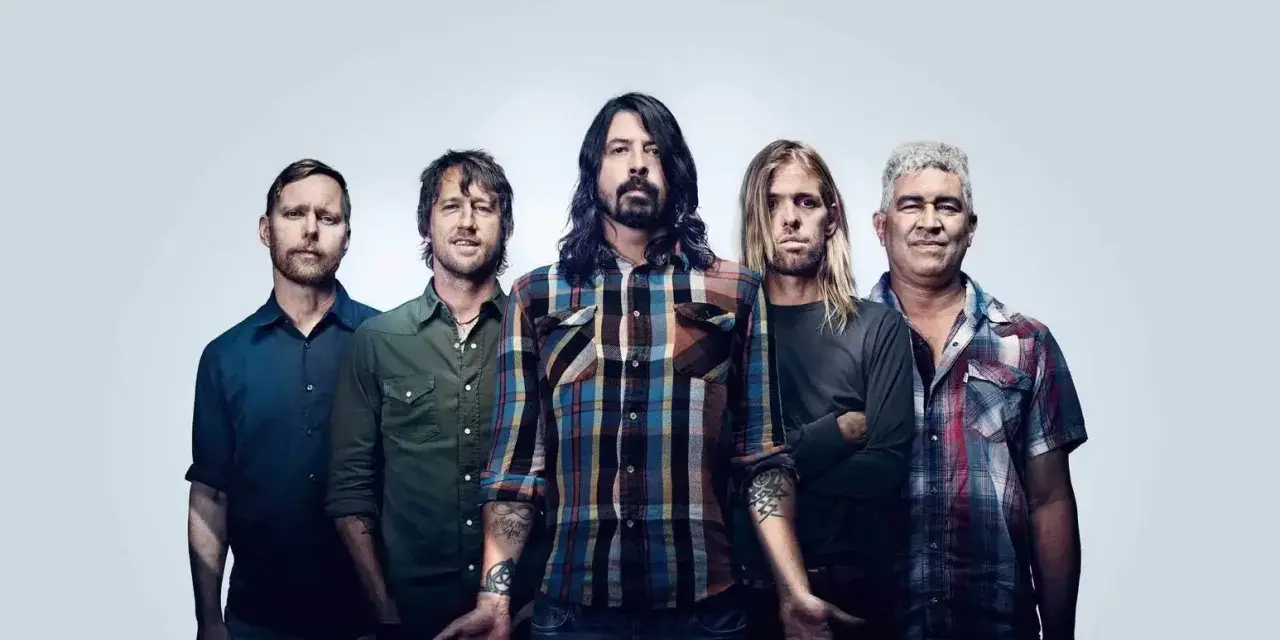 Les cinq membres du groupe Foo Fighters posent ensemble, prêts à faire vibrer le public avec leur musique.