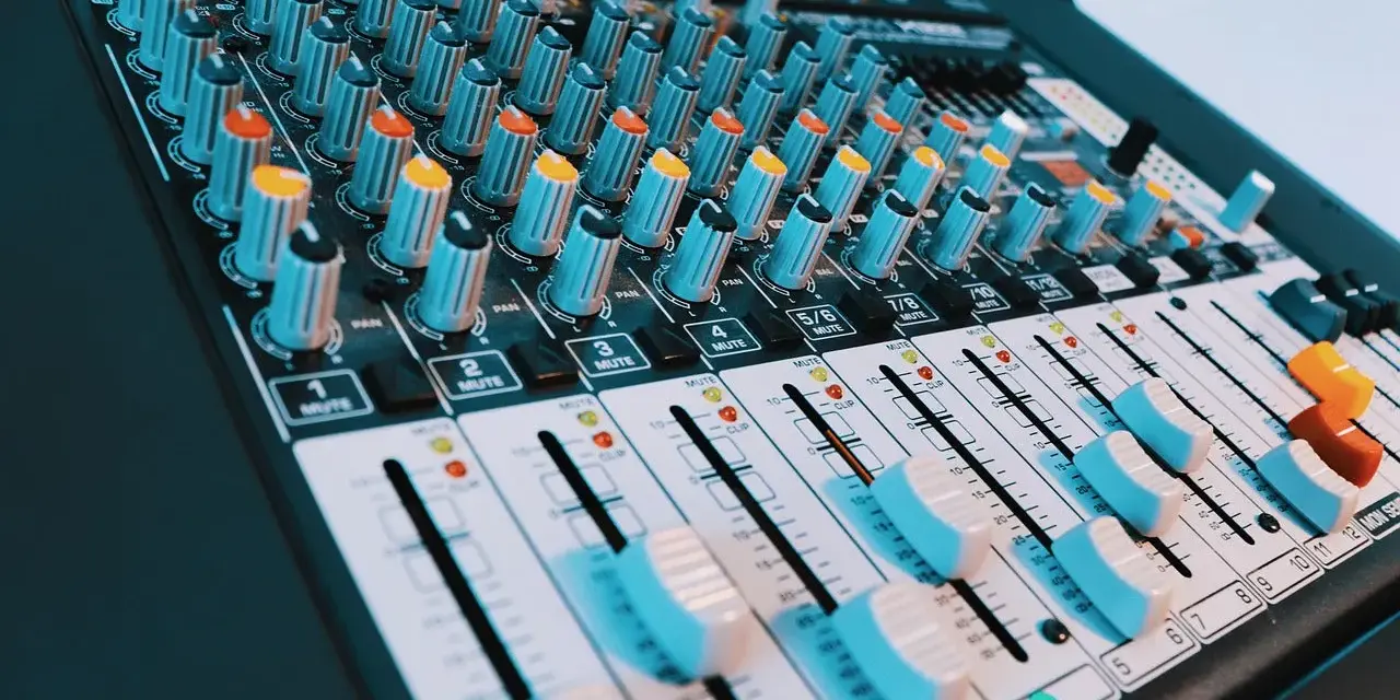 Console de mixage audio avec de nombreux boutons et curseurs. Les niveaux de volume peuvent être ajustés pour un son parfait, peut-être jusqu'à 40 décibels.