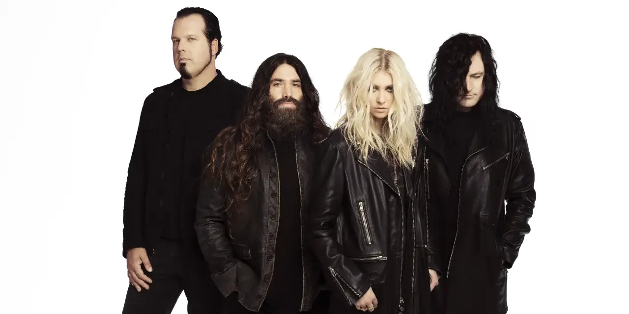 Les membres de The Pretty Reckless, un groupe de rock, posent ensemble sur fond blanc.