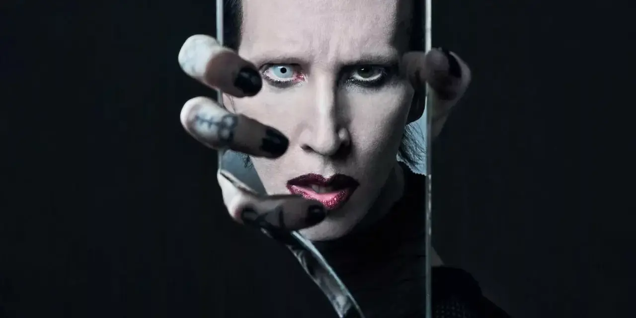 Marilyn Manson, visage décomposé dans un miroir brisé, évoquant l'esthétique sombre de ses albums.