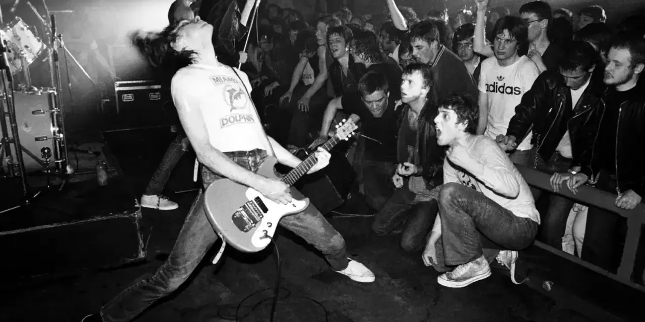 Un groupe rock irlandais des années 90 en pleine action. Le guitariste, cheveux au vent, électrise la foule en délire.