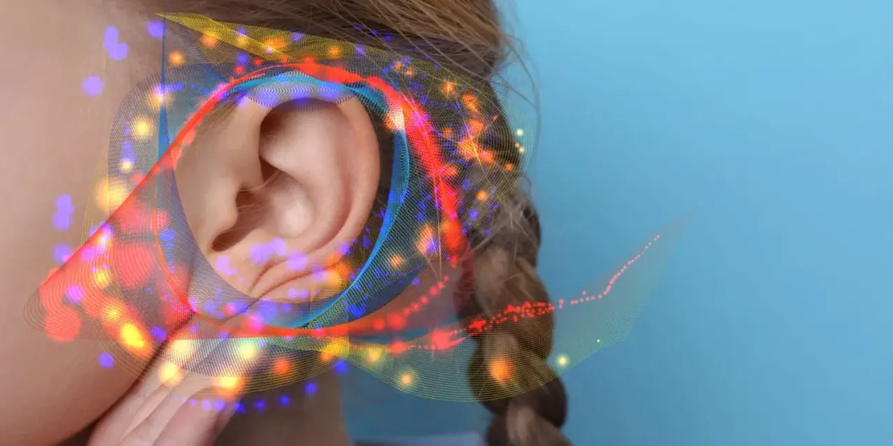 Une oreille capte des ondes sonores colorées, suggérant un seuil de douleur db.