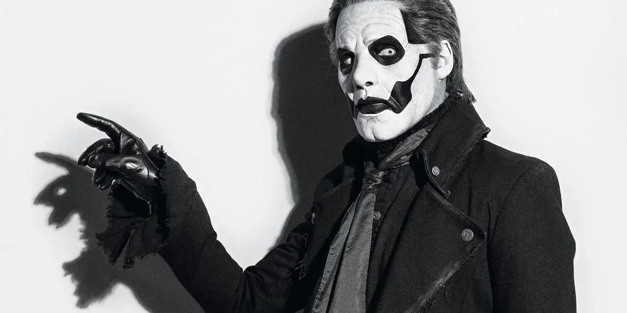 Le chanteur de Ghost, Papa Emeritus IV, pointe du doigt avec un gant noir, son visage maquillé en squelette.