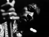 Gros plan en noir et blanc de Jimi Hendrix jouant de la guitare, évoquant l'esprit de ses albums légendaires.