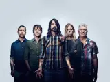 Les cinq membres du groupe Foo Fighters posent ensemble, prêts à faire vibrer le public avec leur musique.