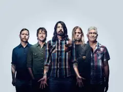 Les cinq membres du groupe Foo Fighters posent ensemble, prêts à faire vibrer le public avec leur musique.