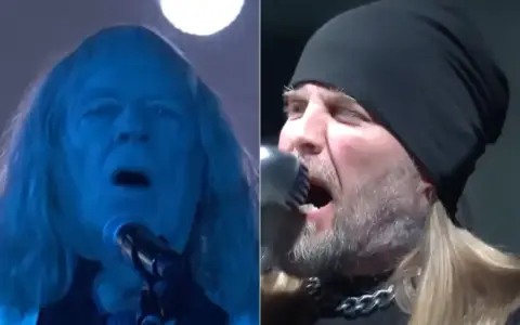Deux chanteurs de Drowning Pool en pleine performance, l'un éclairé en bleu, l'autre avec un bonnet noir.