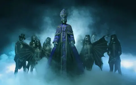 Les membres de Ghost (groupe) apparaissent dans une brume bleutée, le leader en robe violette imposante, entouré de squelettes masqués et d'une silhouette à chapeau.