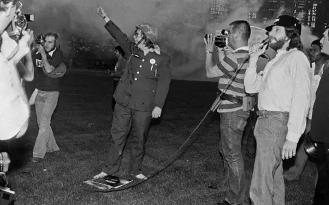 Un homme en uniforme militaire, bras levé, au milieu d'une foule et de caméras. Une scène qui pourrait faire partie de l'histoire du disco.