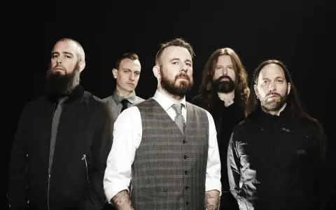 Cinq hommes barbus, membres du groupe In Flames, posent devant un fond noir.