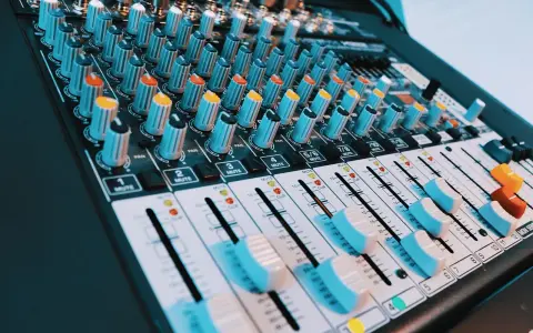 Console de mixage audio avec de nombreux boutons et curseurs. Les niveaux de volume peuvent être ajustés pour un son parfait, peut-être jusqu'à 40 décibels.
