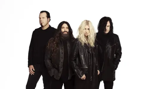Les membres de The Pretty Reckless, un groupe de rock, posent ensemble sur fond blanc.
