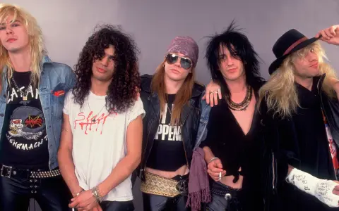Cinq membres d'un groupe rock anglais des années 80 posent ensemble, arborant des coiffures et des tenues emblématiques de l'époque.
