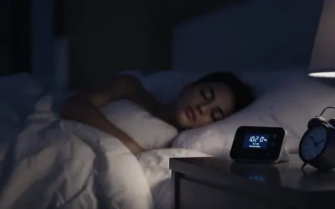 Une jeune femme dort paisiblement. Sur la table de nuit, un réveil affiche 10:20. La question est : combien de décibels pour dormir ?