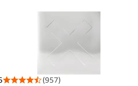 La couverture argentée minimaliste d'un des albums de The xx, avec un grand "X" en relief.