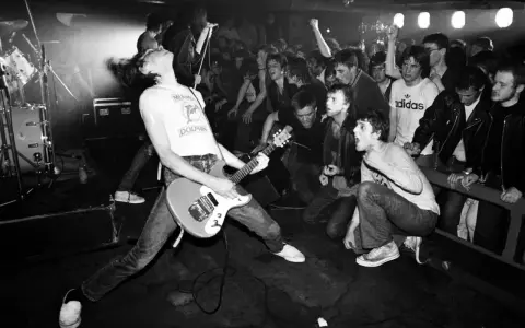 Un groupe rock irlandais des années 90 en pleine action. Le guitariste, cheveux au vent, électrise la foule en délire.