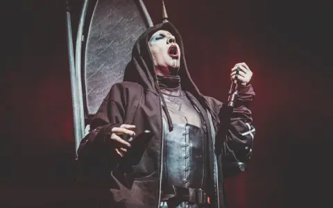 Marilyn Manson, le visage maquillé, chante sur scène, micro en main. Les dernières marilyn manson news le montrent toujours aussi provocateur.