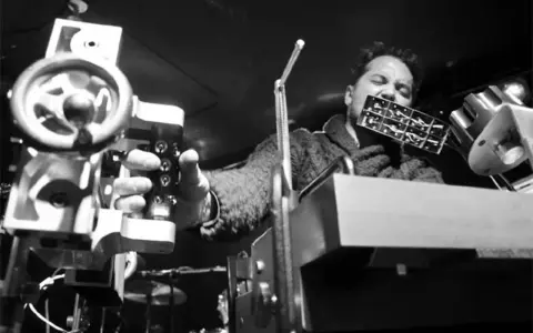 L'auteur, un musicien, joue d'un instrument étrange, tel un punisher sonore, manipulant des machines complexes.