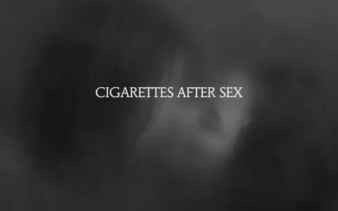 Texte blanc "CIGARETTES AFTER SEX" sur fond sombre et flou, évoquant une ambiance intime et mélancolique.