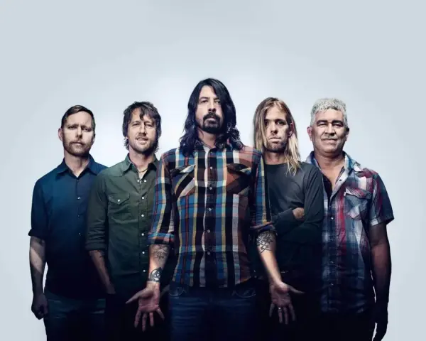 Les cinq membres du groupe Foo Fighters posent ensemble, prêts à faire vibrer le public avec leur musique.