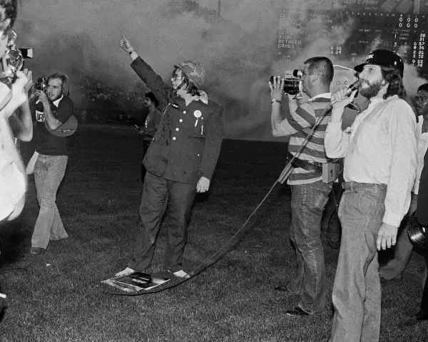 Un homme en uniforme militaire, bras levé, au milieu d'une foule et de caméras. Une scène qui pourrait faire partie de l'histoire du disco.
