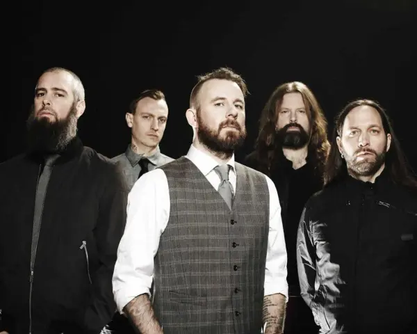 Cinq hommes barbus, membres du groupe In Flames, posent devant un fond noir.