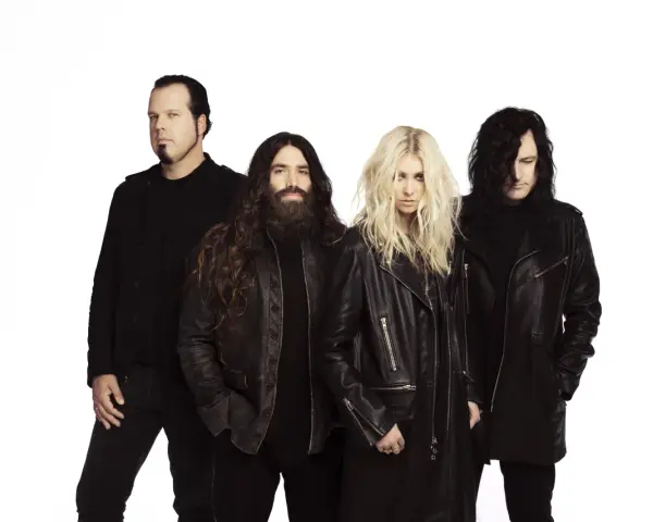 Les membres de The Pretty Reckless, un groupe de rock, posent ensemble sur fond blanc.