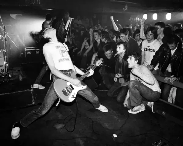 Un groupe rock irlandais des années 90 en pleine action. Le guitariste, cheveux au vent, électrise la foule en délire.
