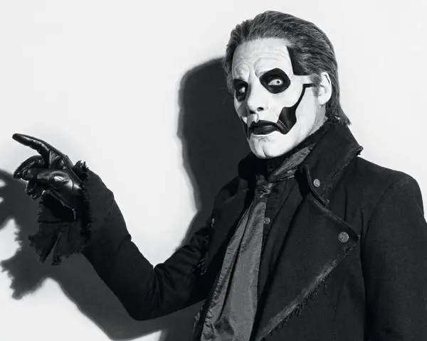 Le chanteur de Ghost, Papa Emeritus IV, pointe du doigt avec un gant noir, son visage maquillé en squelette.