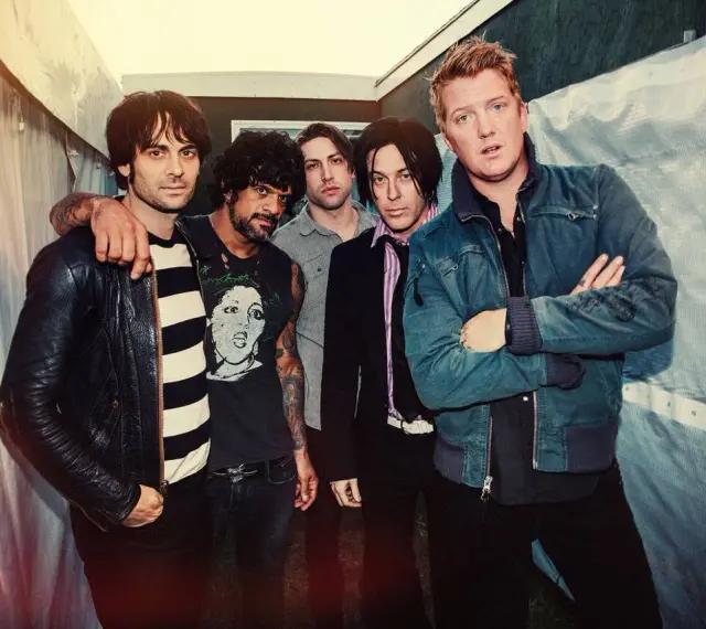 Les membres de Queens of the Stone Age posent ensemble, prêts à enregistrer de nouveaux albums.