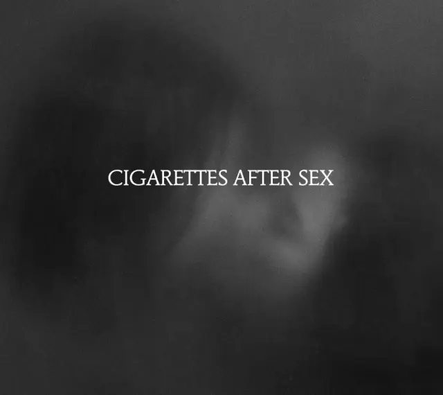 Texte blanc "CIGARETTES AFTER SEX" sur fond sombre et flou, évoquant une ambiance intime et mélancolique.