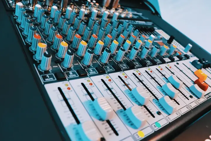 Console de mixage audio avec de nombreux boutons et curseurs. Les niveaux de volume peuvent être ajustés pour un son parfait, peut-être jusqu'à 40 décibels.